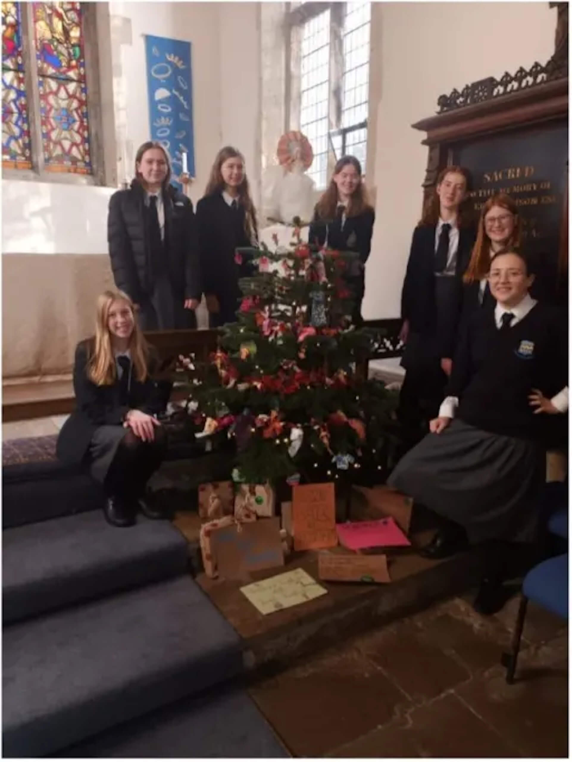 Pocklington senior students standing around a christmas tree