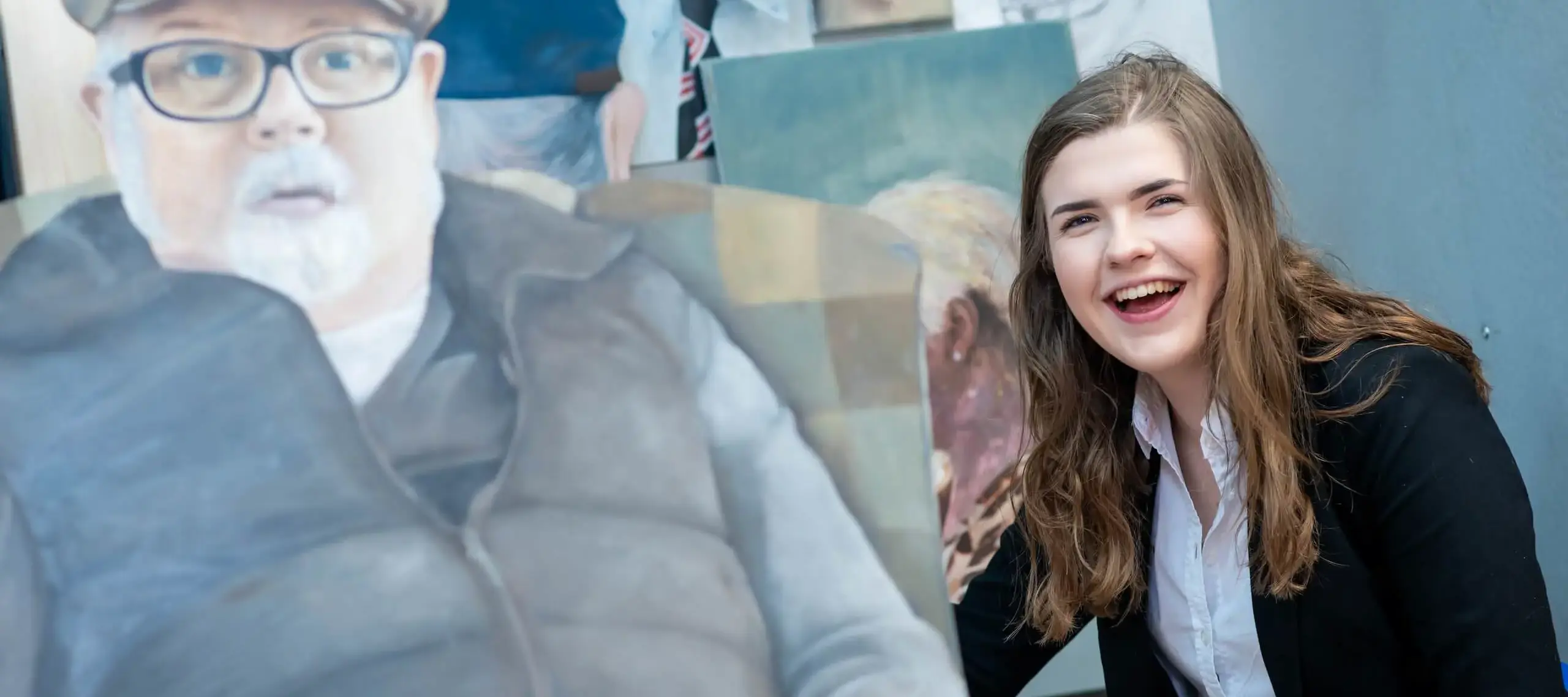 Pocklington Sixth Form student next to painting in art room