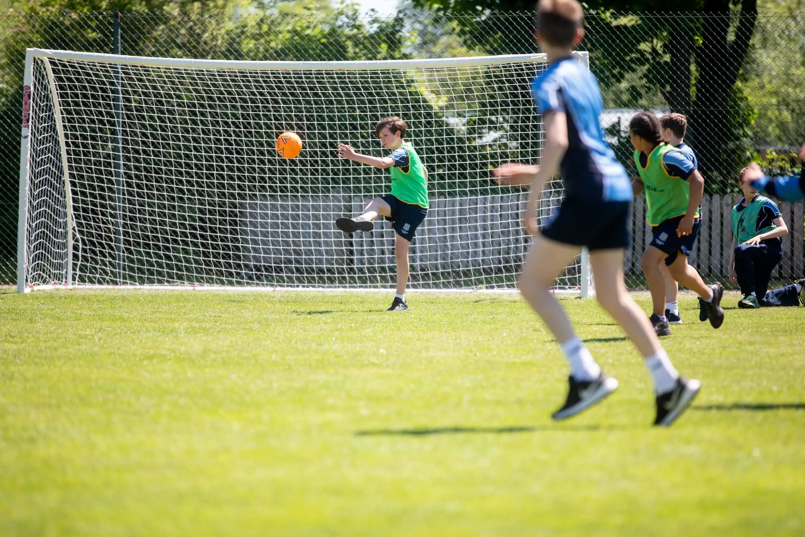 Pocklington School pupils kicking ball outside on campus grounds 