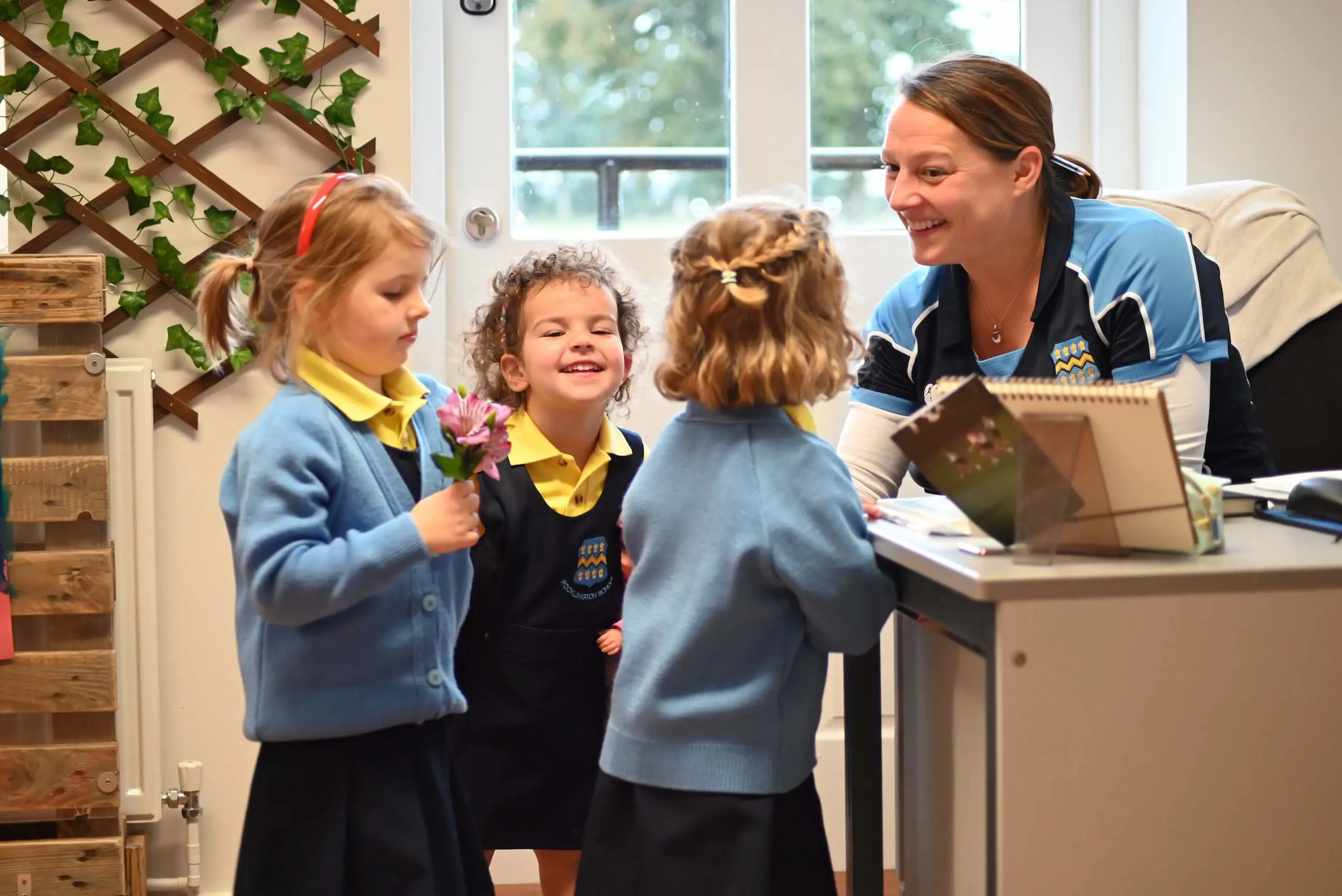 Pocklington pre-school teacher talking to three pre-school children.