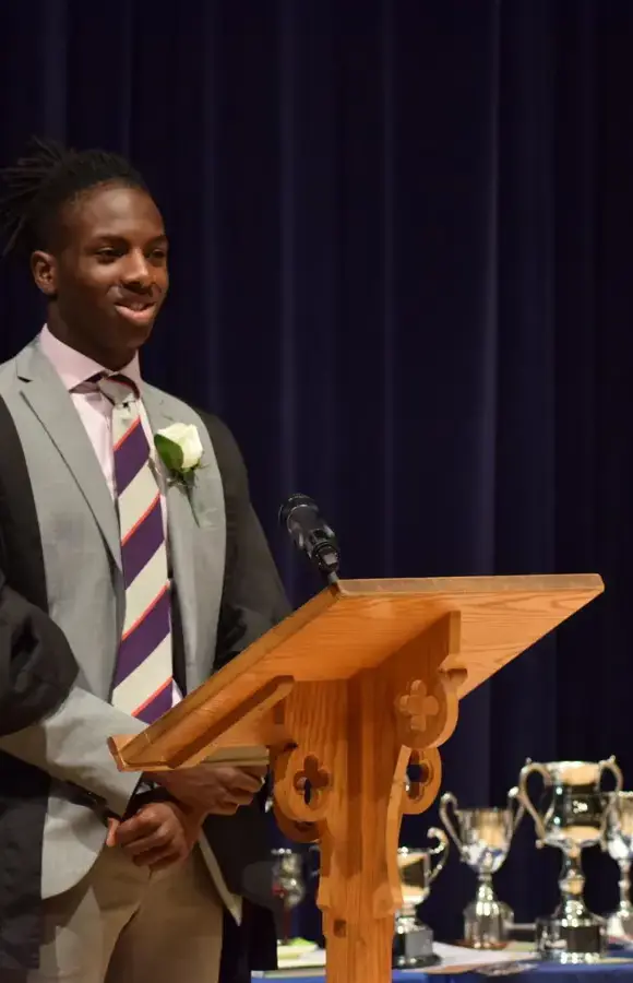 Pocklington School Sixth Form prefect making a speech at a lectern 