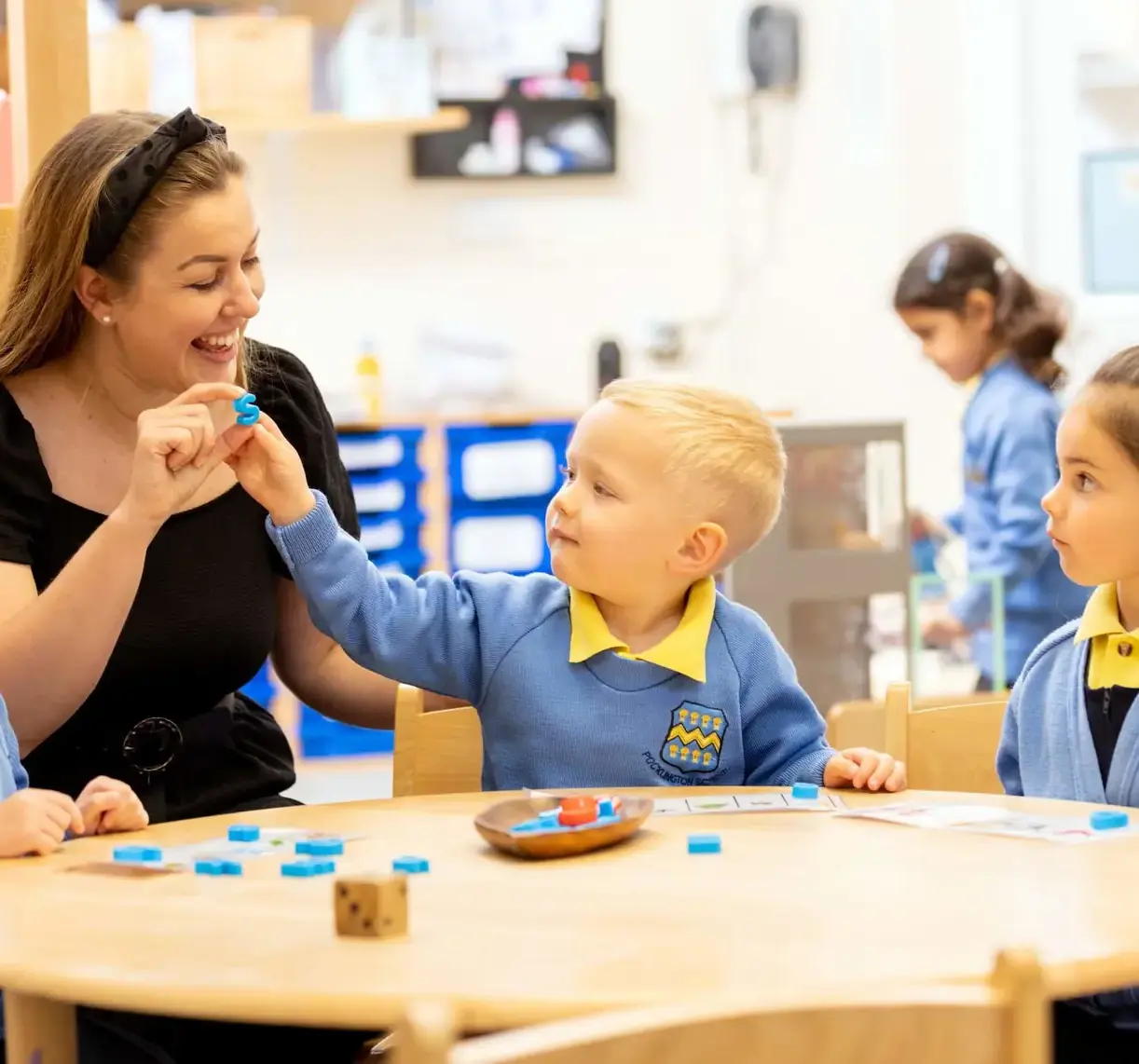 Pocklington Prep School teacher laughing and playing with Pre-Prep pupils