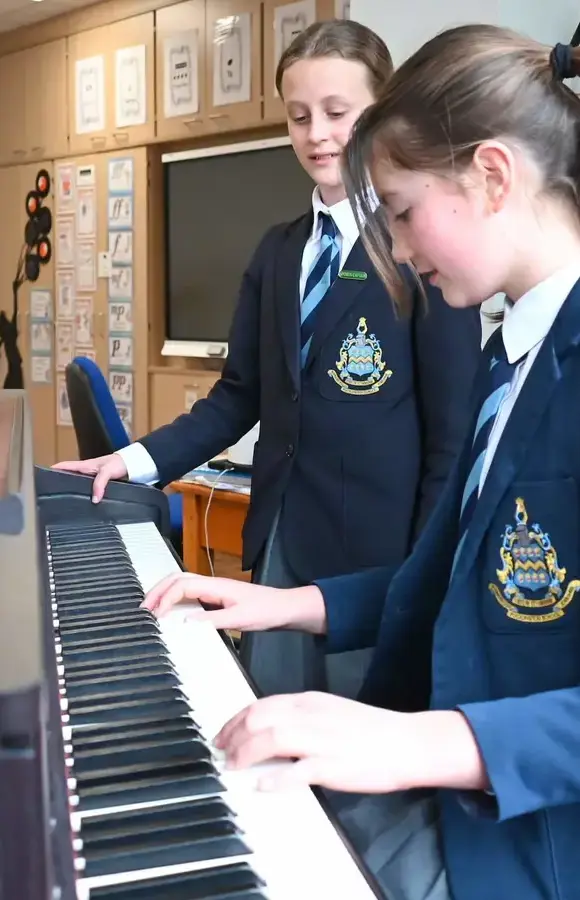 Pocklington Prep pupils play the piano together in the music room as part of their specialist music teaching 