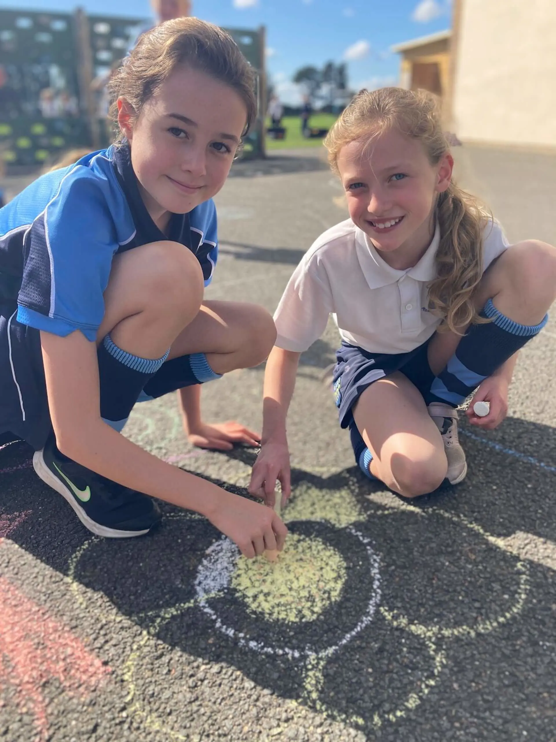 Two Pocklington Prep school pupils drawing in chalk on the pavement