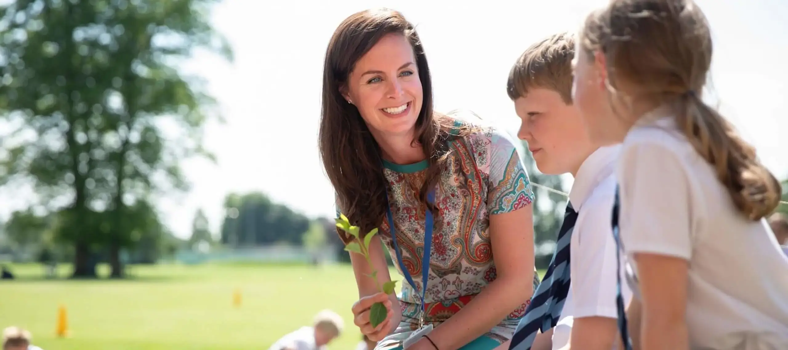 Pocklington Prep School teacher sits outside chatting with pupils 