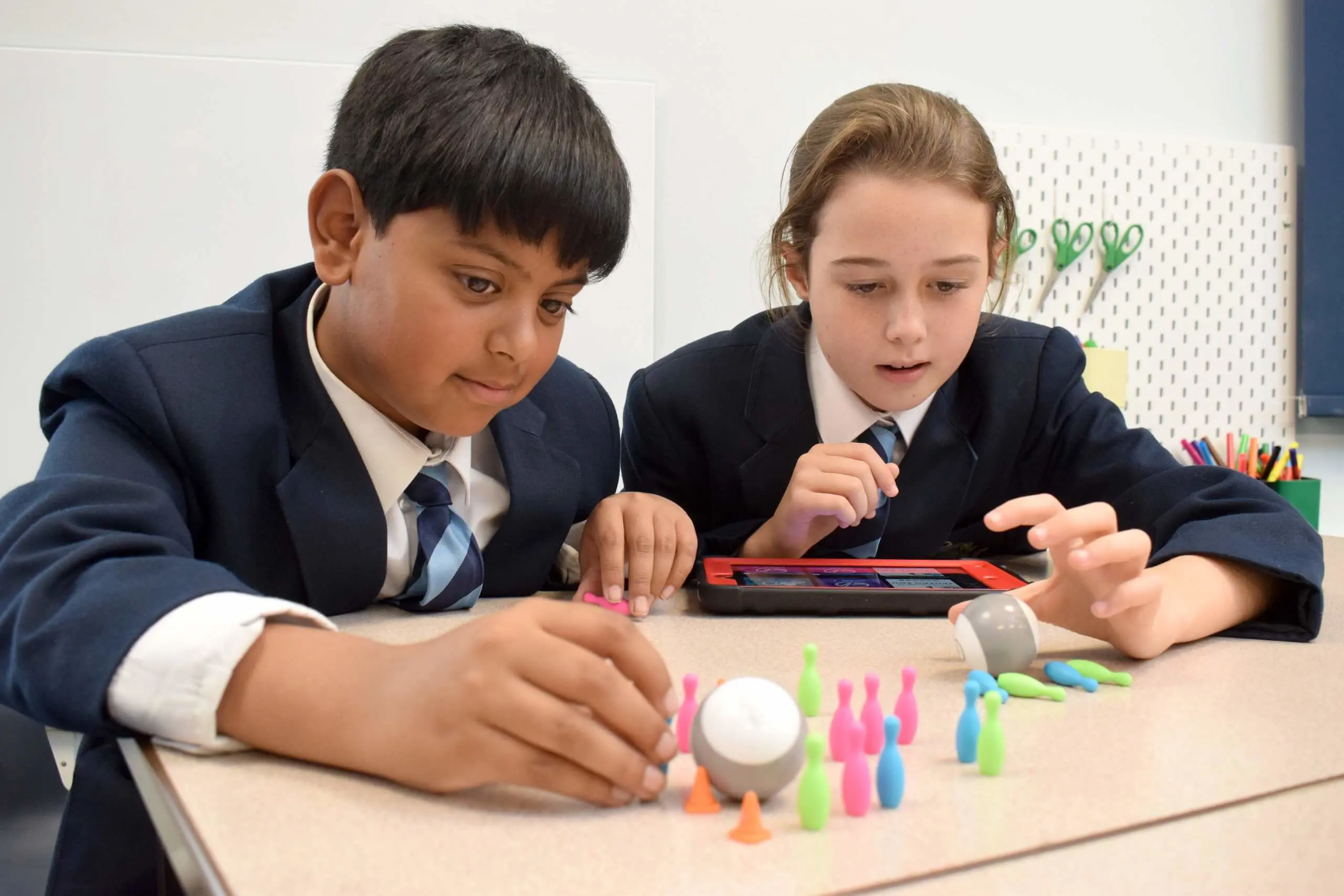 Two Prep School pupils play a mini bowling game together using an iPad. 