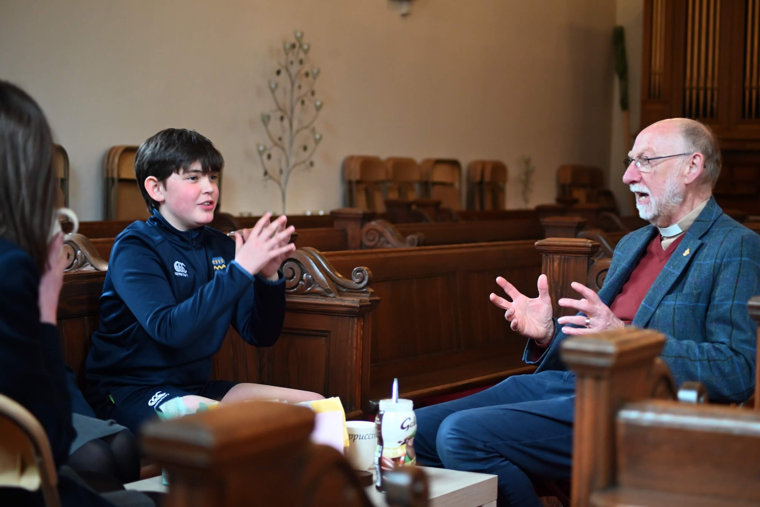 Pocklington School Chaplain sits talking with a Prep School pupil 