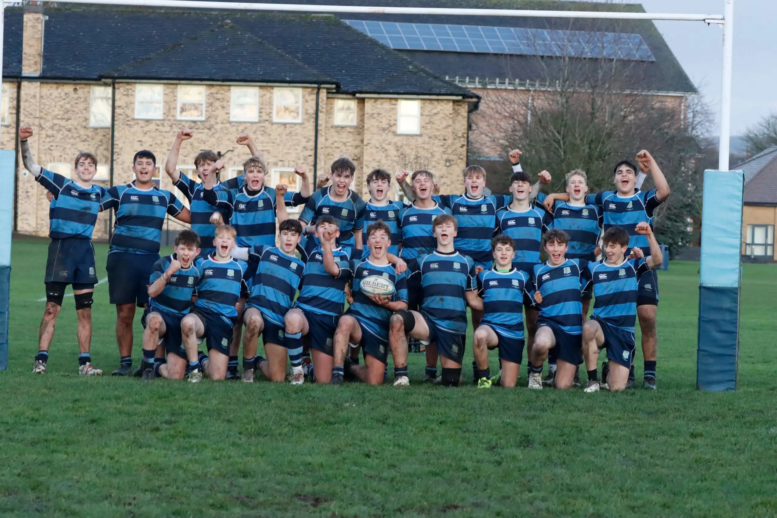 Pocklington School boys rugby team celebrating in a photo on the rugby pitch