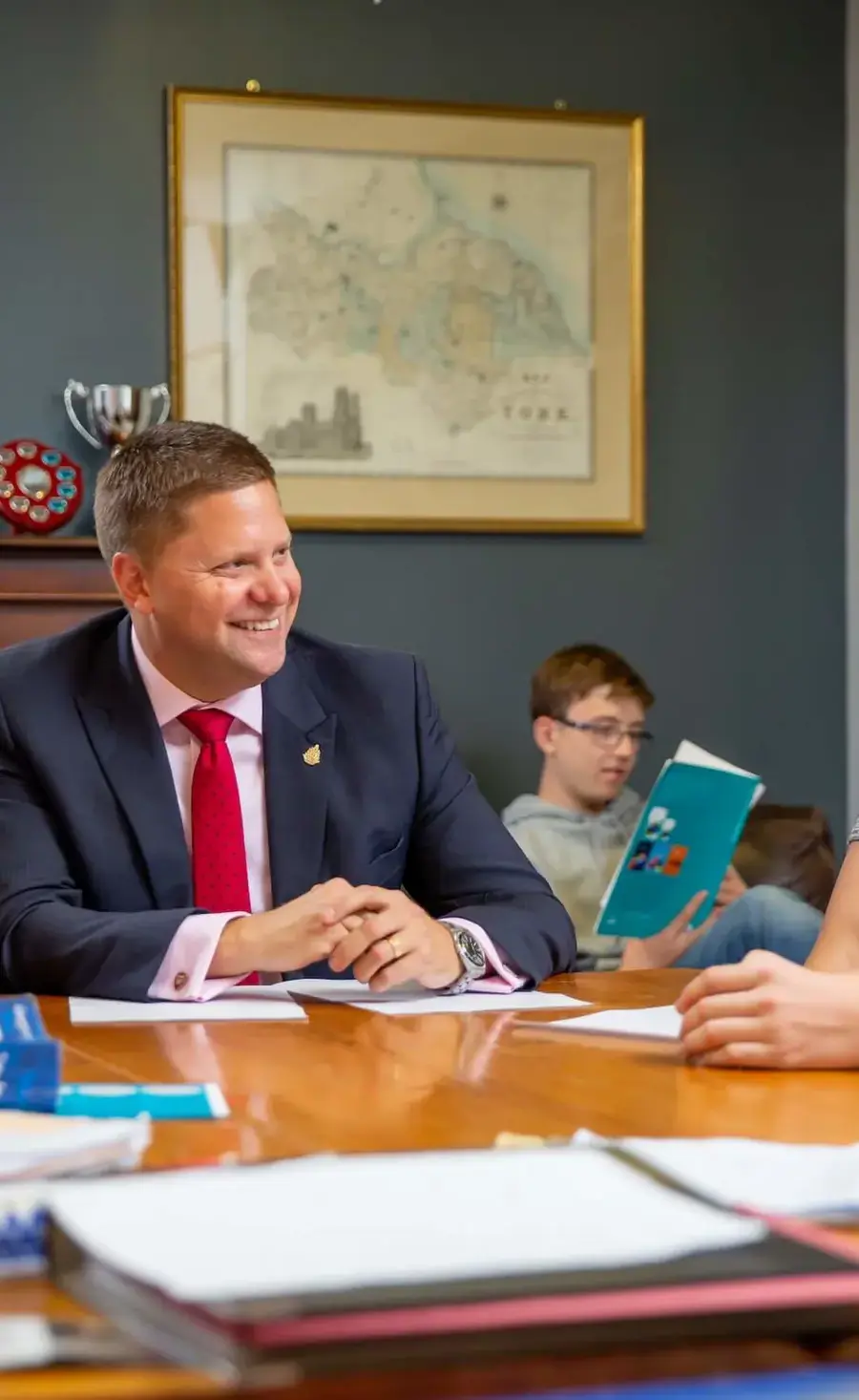 Headmaster chatting to boarding pupils around a table