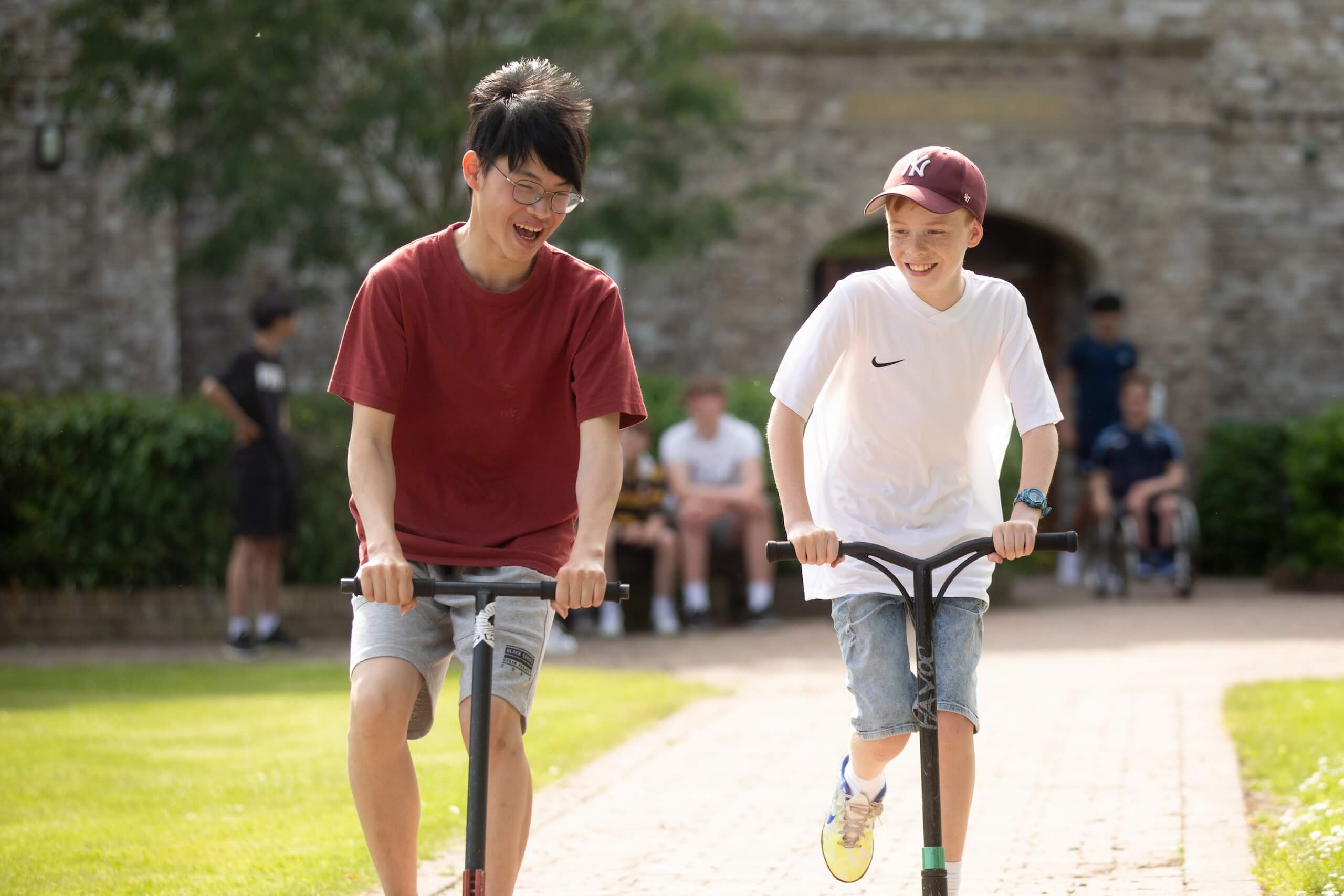 Boarders on scooters outside boarding house