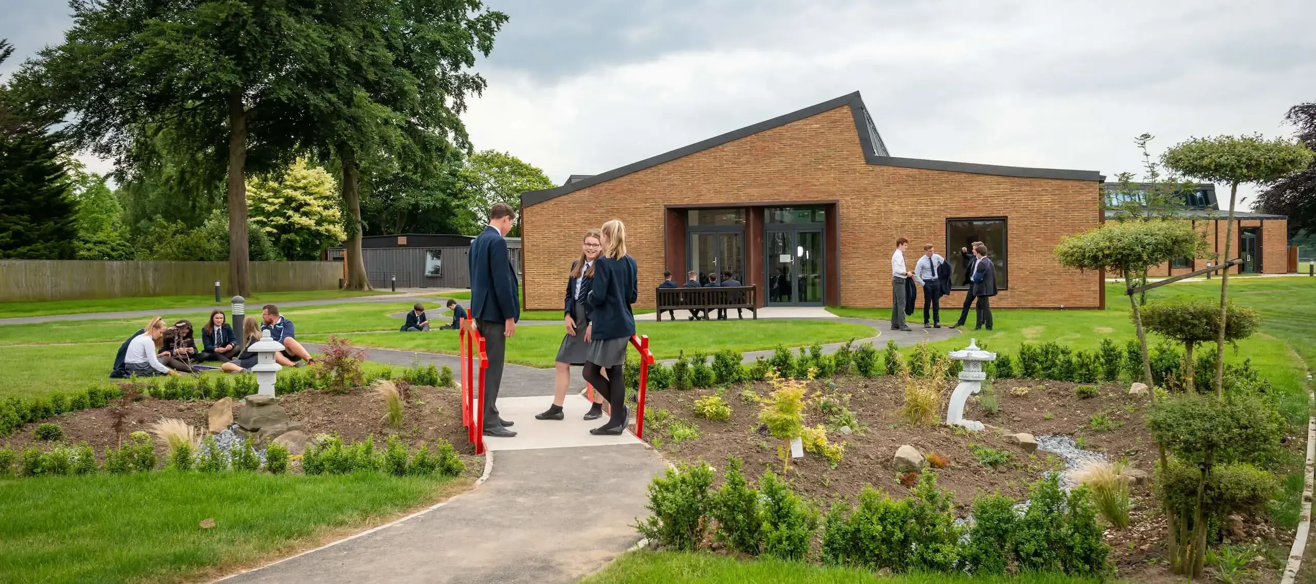 Pocklington School art and design technology centre with red bridge and Japanese garden in foreground