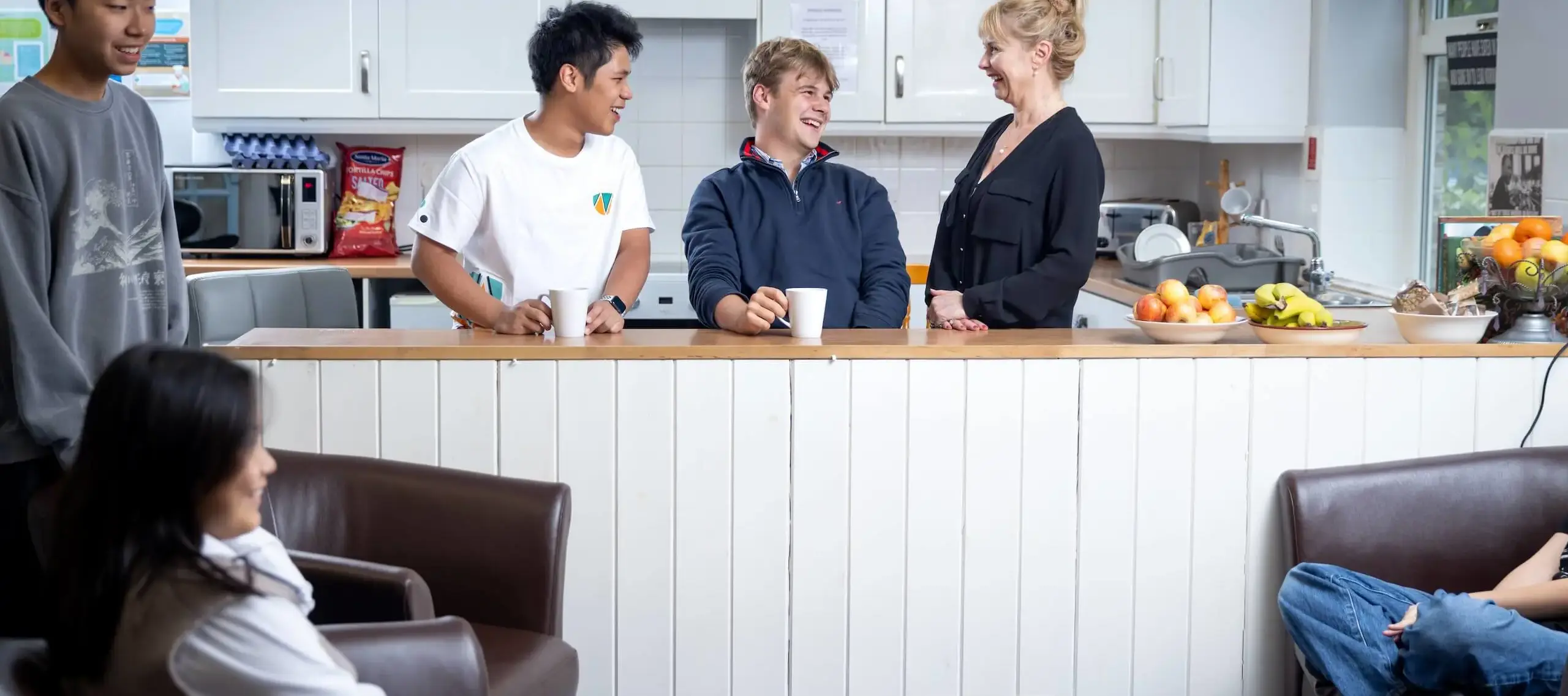 Pocklington School boarding pupils with houseparent in kitchen