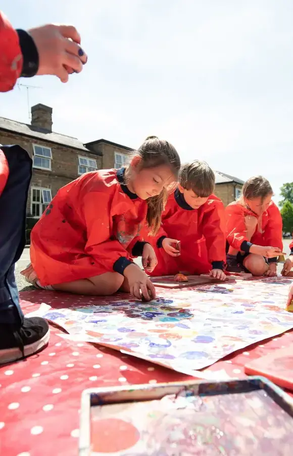 Pocklington Prep school pupils paint on the floor outside