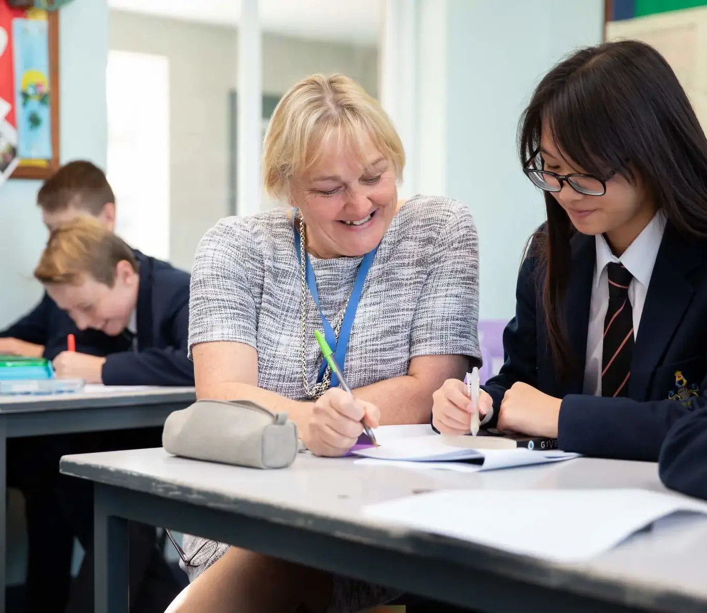 Teacher and international student in class looking at a book