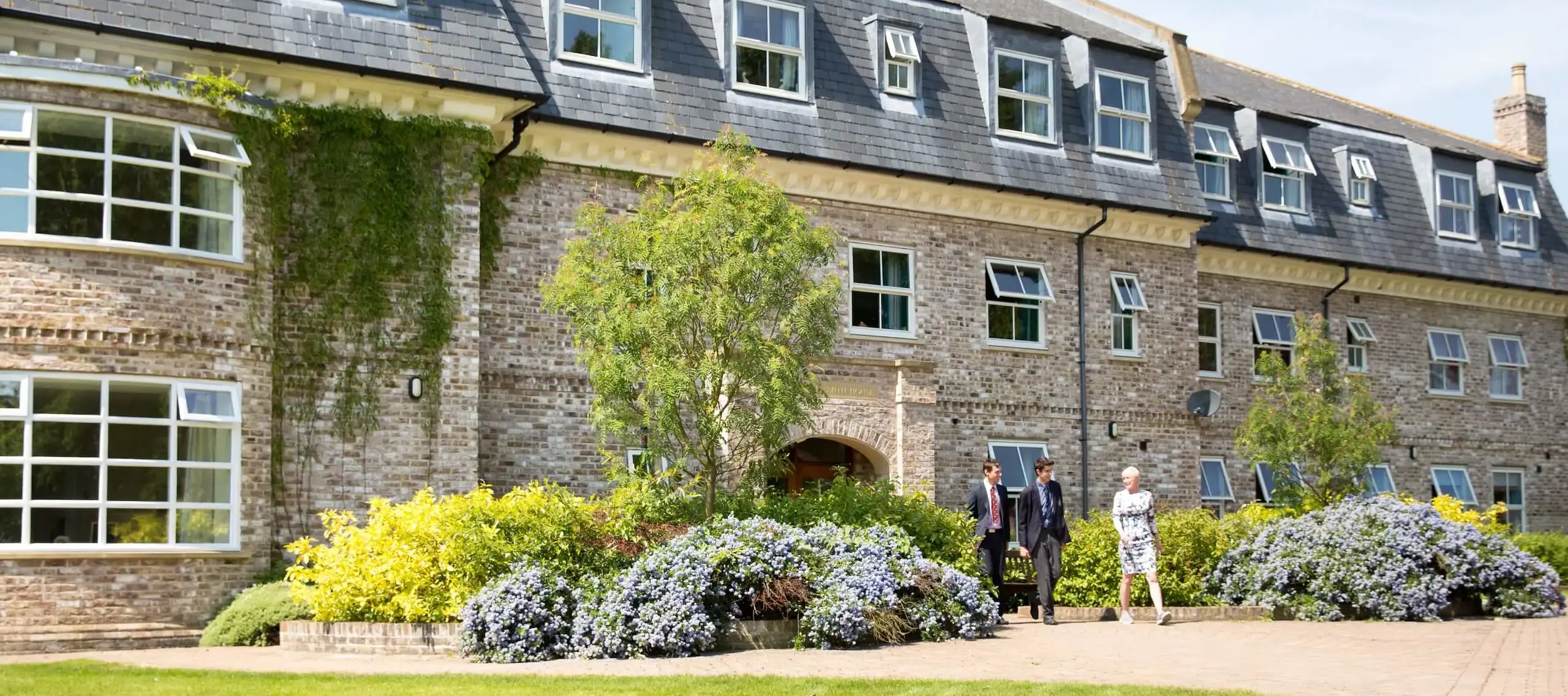 Pocklington School boarding house, large modern building with pupils and staff walking in front