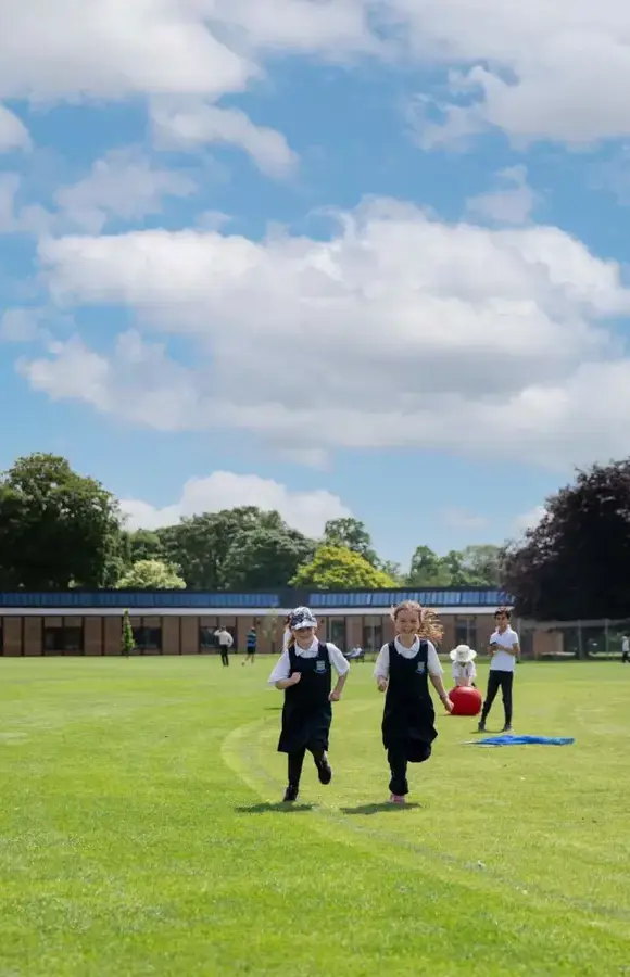 Two Pocklington Pre-Prep pupils running on the campus fields