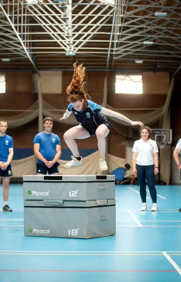 Pocklington School pupil in sports kit jumping onto high sports equipment