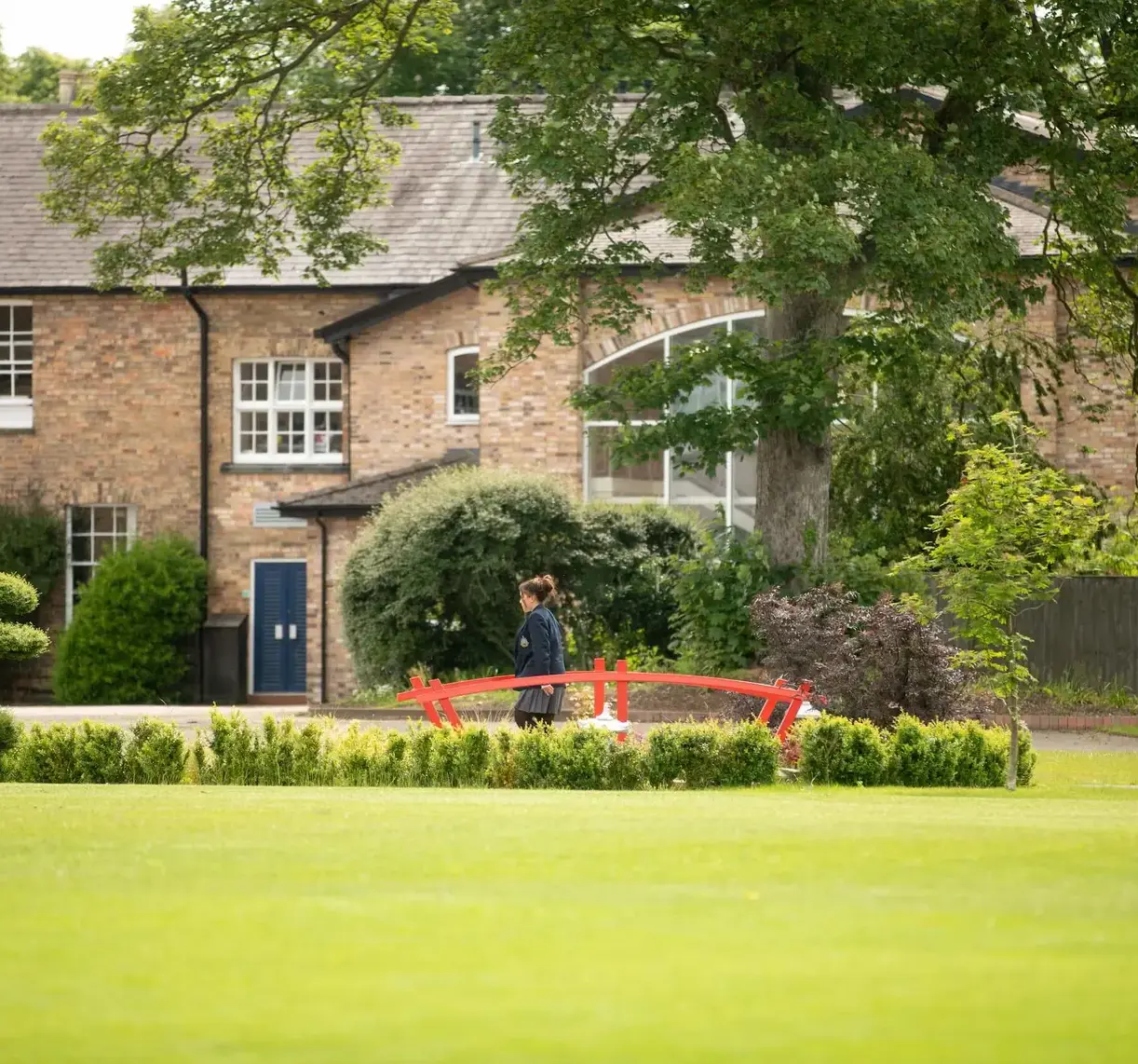 Pocklington School pupils walking over red bridge on campus