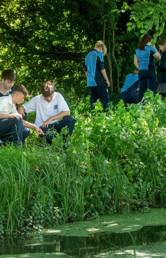 Pocklington School pupils outside by lake on campus 