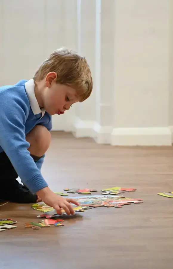 Pre-School pupil doing a jigsaw on the floor