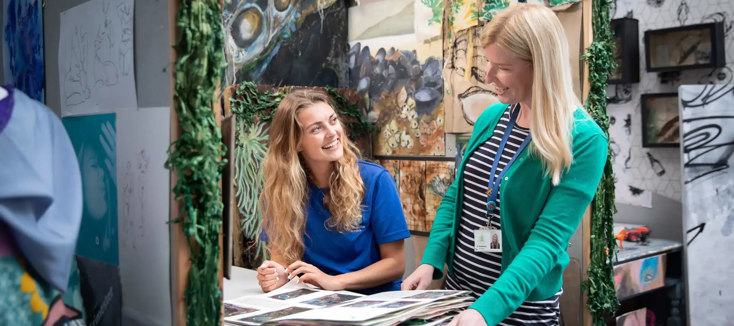 Pocklington School art teacher with art student and walls of paintings