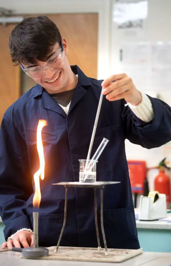 Pocklington School Sixth Former in chemistry class with bunsen burner and test tube