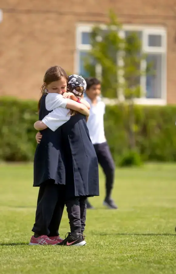 Pocklington Prep School pupils standing outside the school grounds, hugging 