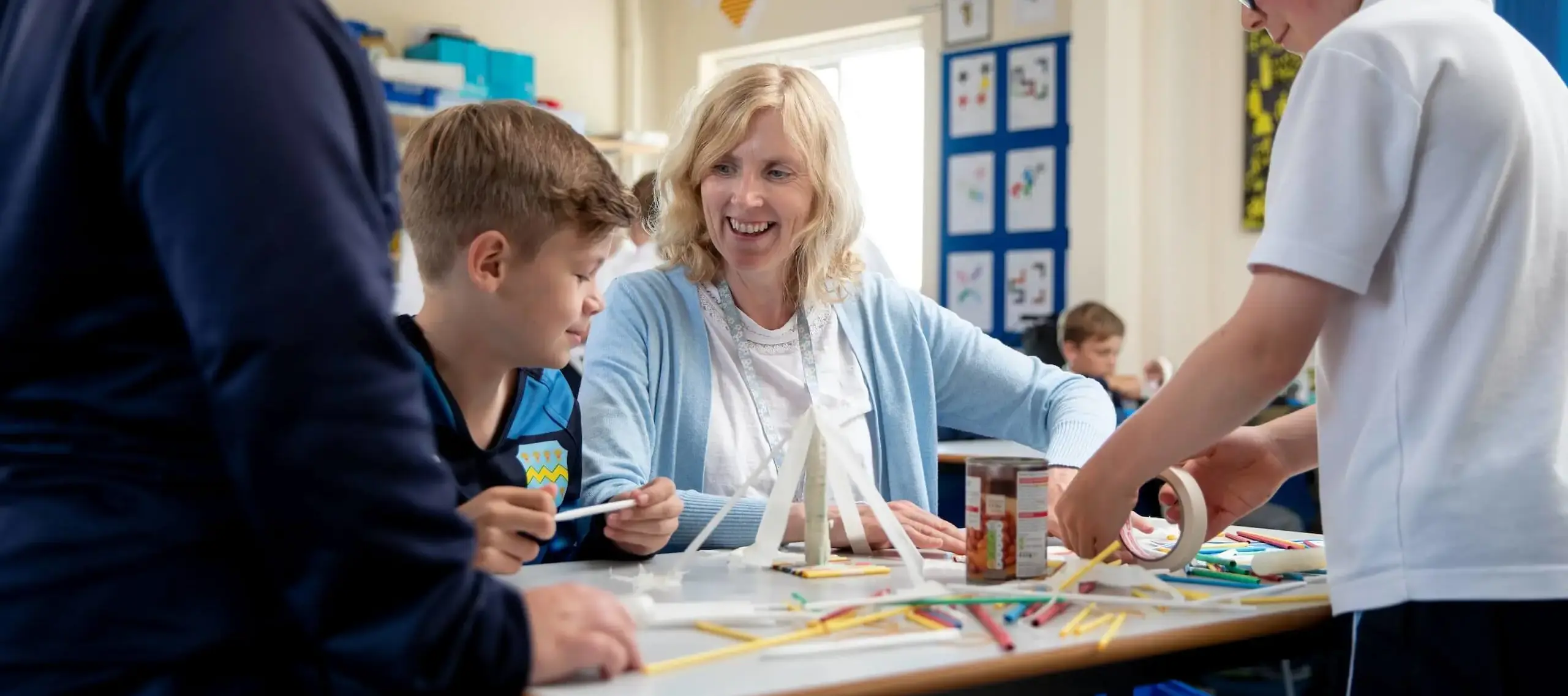 Pocklington Prep School pupils stand around a table working with a member of staff 