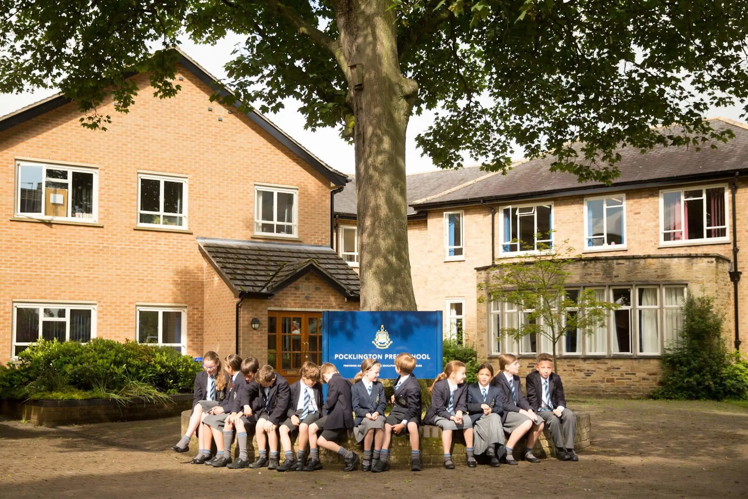 Pocklington Prep students sitting around a tree outside Pocklington Prep School 