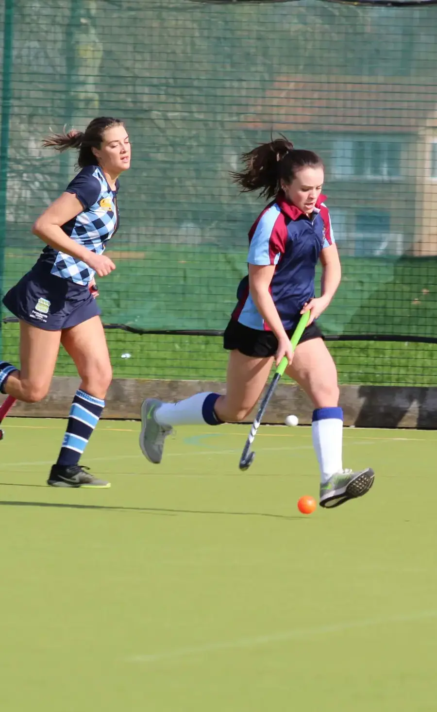 Alumni and Pocklington School players in pursuit of the ball during a hockey game on the astro pitch at Pocklington School