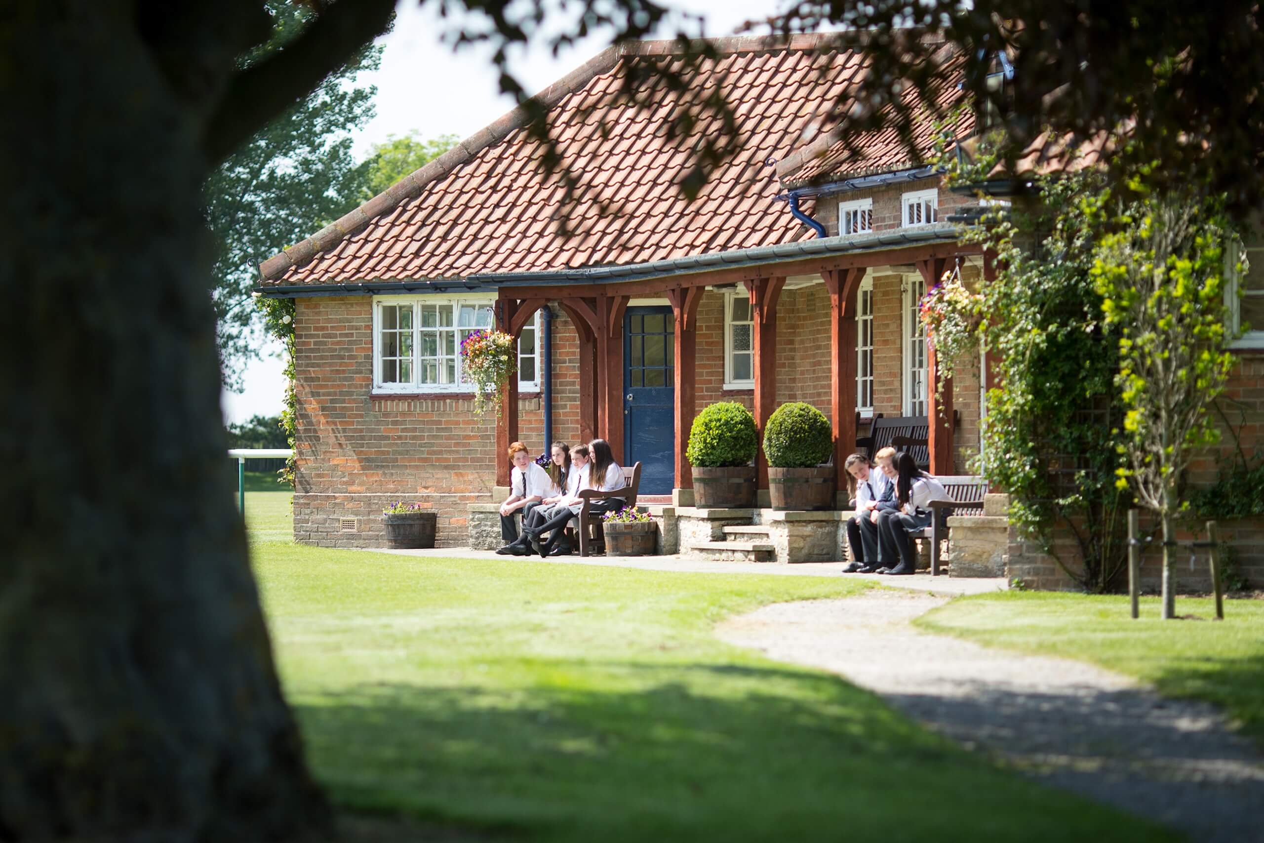 Pupils sat on benches outside the Pocklington School cricket pavilion