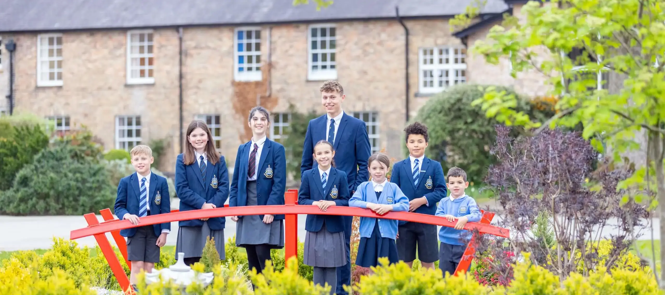 Group of Pocklington School pupils aged from 2-18 on red bridge