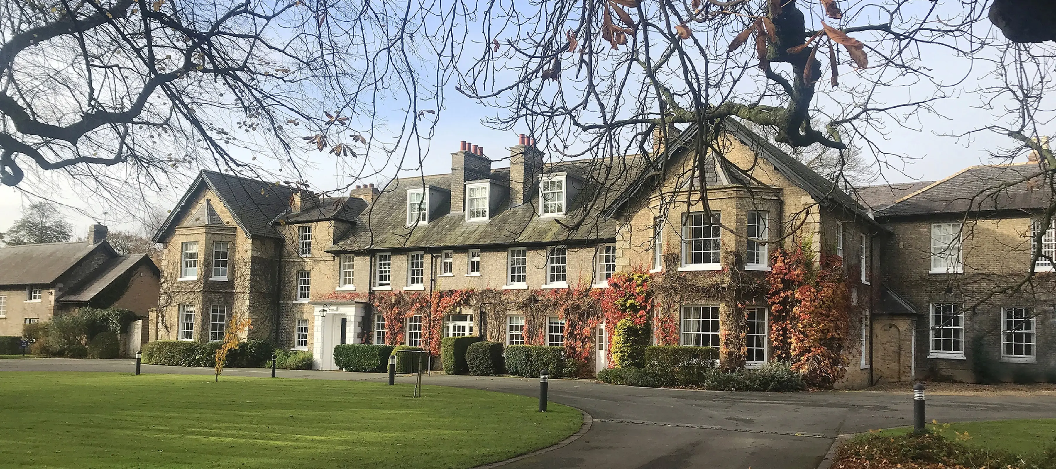 Picture of the front of Pocklington School building in Autumn with red virginia creeper.